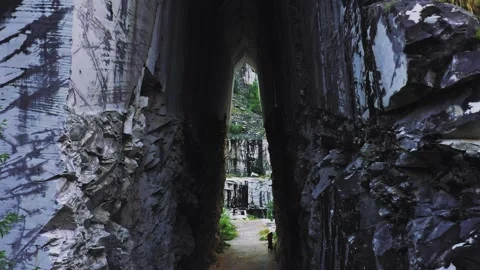 Drone fly through rock-cut entrance of abandoned marble quarry in Carrara, Italy Stock Footage 250341026