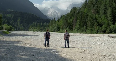 Drone Fly Through Two Men Running On Riverbed Towards Woods Stock Footage 112217028