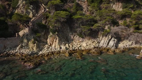 Drone flyback revealing wild emerald bay and coastal cliffs Stock Footage 321346183
