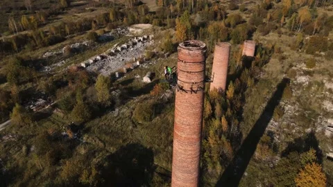 A drone flyby of an abandoned pipe on which people are standing Stock Footage 211362374