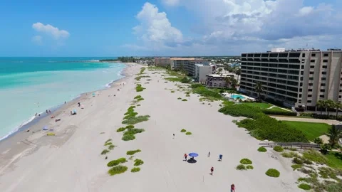 Drone Flyby Along Venice Beach Florida With Hotel Ocean Waves And Beachgoers Vídeo Stock 339297760
