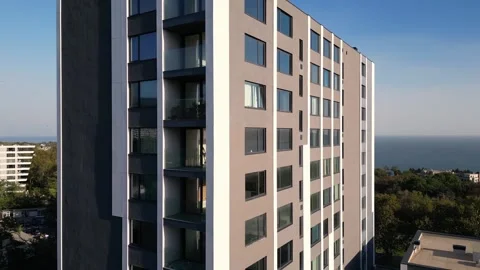 A drone flyby showcasing a modern high-rise building with sleek balconies and Stock Footage 286842486