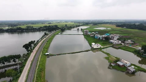 Drone Flyforward of Rural Fish Ponds and Railway Line in Ishwardi Stock Footage 335878389
