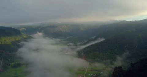 Drone flying above cliff and valley covered in thick fog and clouds Stock Footage 333407823