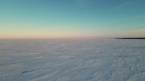Drone flying above a large snow-covered lake late in the day. Stock Footage 254702126