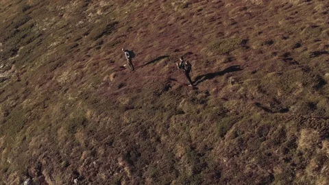 Drone flying above mountains two tourists walking on mountain Stock Footage 104303161