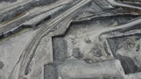 Drone flying above open mining pit turning out of pit while truck drives by 스톡 동영상 280010662