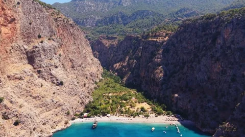 Drone flying above pirate ship docked at Butterfly Valley in Turkey Stock Footage 345542269