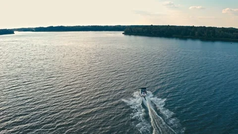 Drone flying above a river with a  fast driving speedboat  while sunset.  Aer Stock Footage 194962807