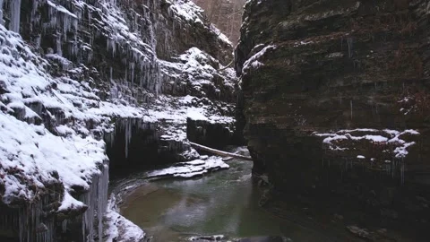 Drone flying above a river flowing through a canyon during winter time Stock Footage 231798455