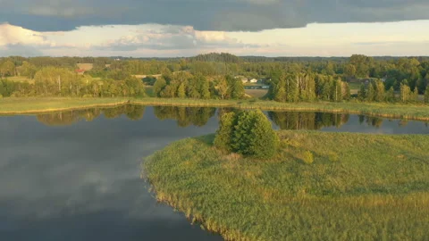 Drone flying above small sunrise lake island towards tents and cars on shore Video stock 152627872