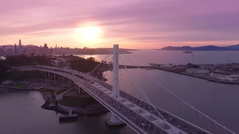 Drone flying above white tower of Bay Bridge, Epic rose golden sunset over Bay Stockbeeldmateriaal 244682628