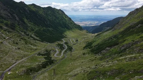 Drone flying above winding Transfăgărășan road beneath dramatic clouds 스톡 동영상 340824569