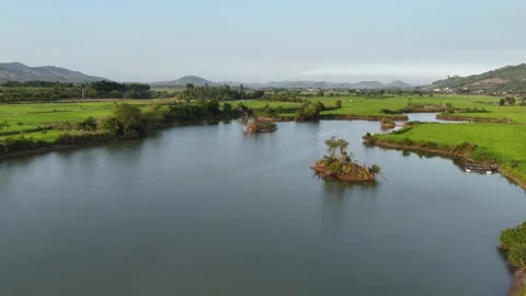 Drone flying across Bau Lon reservoir at sunset with distant boats 스톡 동영상 336972666