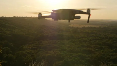 A drone flying against the backdrop of a beautiful mountain area during sunset Stock Footage 137808345