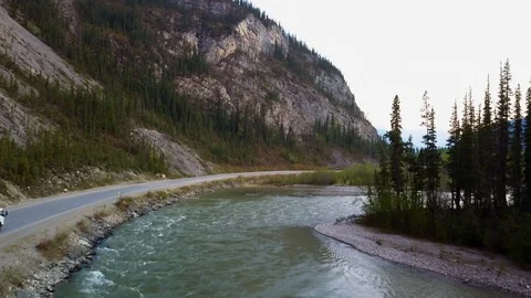 Drone flying along a beautiful river in the mountains with overland RV Stock Footage 114636533