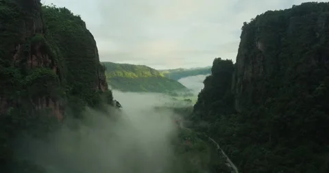 Drone flying along dramatic cliff edge with dense fog and clouds Stock Footage 333407753