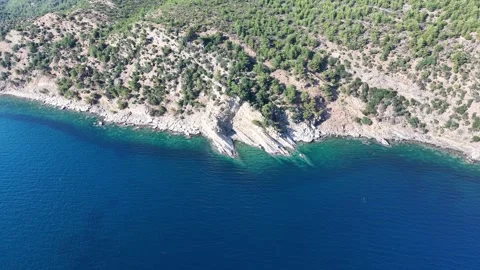 Drone Flying Along Forested Rocky Coast and Blue Sea Stockbeeldmateriaal 340509318