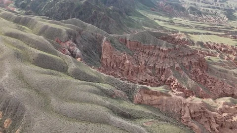 Drone flying along red eroded sandstone ridges, Kok-Moinok Canyons, Kyrgyzstan Stock Footage 347239483