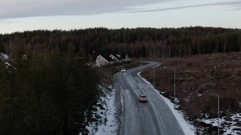Drone flying along road as two cars pass by Stock Footage 124030554