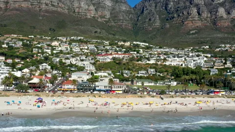 Drone flying along the side of a very busy Camps Bay beach at noon Stock Footage 170726472