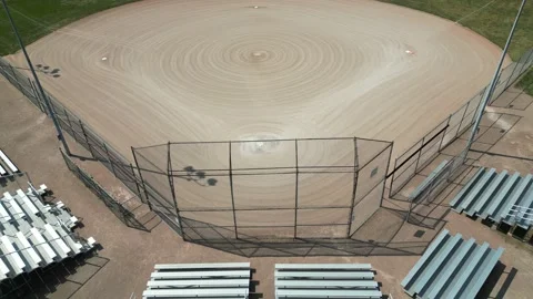 Drone flying up and tiltind down over empty softball diamond Video stock 246566604