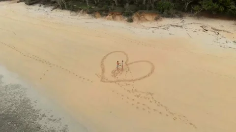 Drone flying around the couple standing and circling holding hand in the big hea Stock Footage 130839780