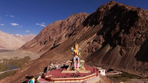 Drone flying around the serene face of Maitreya Buddha watching over Nubra Stock Footage 310900524