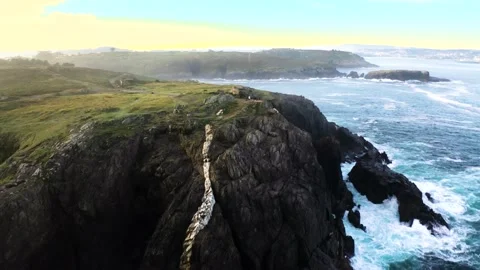 Drone flying away from a man standing on the edge of a huge ocean cliff 库存影片 168758962