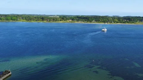 Drone flying away from small local ferry over small strait 4K Stock Footage 236723297