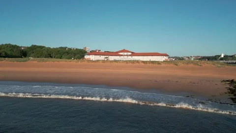 Drone flying back and up over waves breaking on Littlehaven beach Stock Footage 315030247