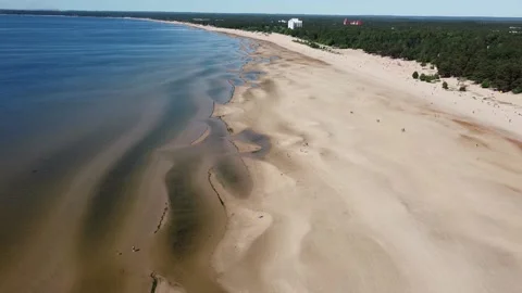 Drone Flying back green Forest low Tide on the Sea Beach people walking Stock Footage 134284840