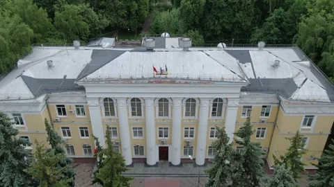 Drone flying backward above administration building roof Stock Footage 333415388