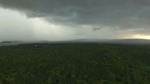 Drone flying backward exposing large scale storm coming in over water Video stock 94865578