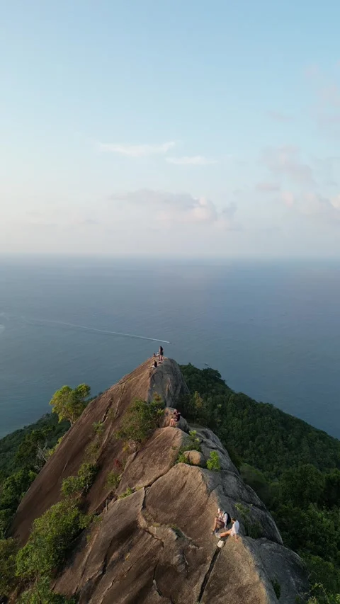 Drone Flying Backward from Hikers on Mountain Peak Overlooking the Ocean in Koh Stock Footage 335813445