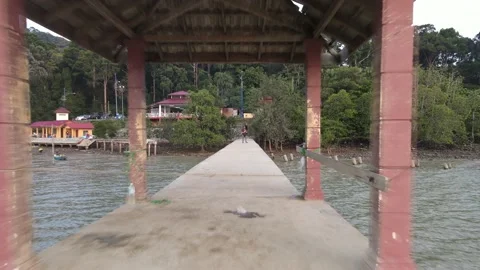 Drone flying backward from jetty and passing through rest area in Teluk Kemang Stock Footage 150721607