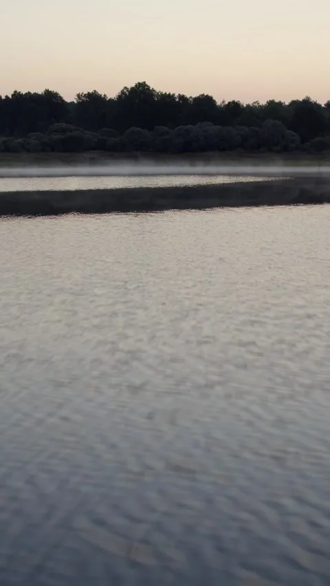 Drone flying backward over calm La Cuerda del Pozo Reservoir in Soria 動画素材 342607447