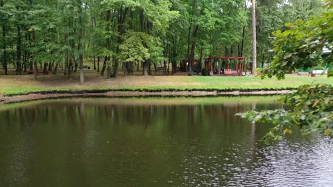 Drone flying backward over park pond Vidéo 325662920