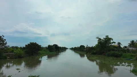 Drone flying backward from a stormy sky to an alluvial canal Vidéo 337529061