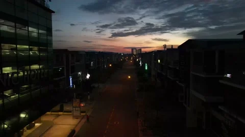 Drone flying backward from sunrise and passing through shops Stock Footage 150111764