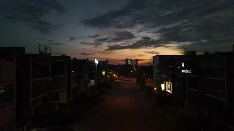 Drone flying backward from sunrise and passing through shops Stock Footage 150112253
