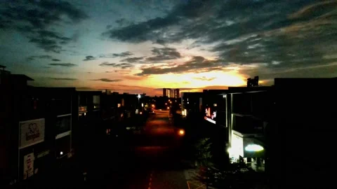 Drone flying backward from sunrise and passing through shops Stock Footage 150112426