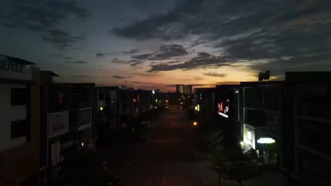 Drone flying backward from sunrise and passing through shops Stock Footage 150112451