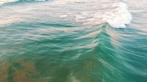 Drone flying backwards behind the ocean waves over amazing sea foam texture Stock Footage 130935846