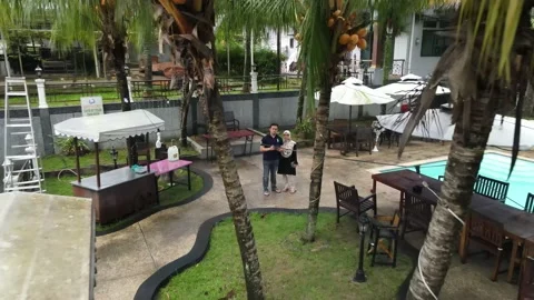 Drone flying backwards from Couple and passing through tree in Penang Video stock 149947612