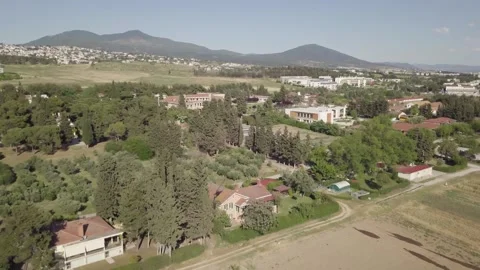 Drone flying backwards over farm with mountains in background Stock Footage 257773017