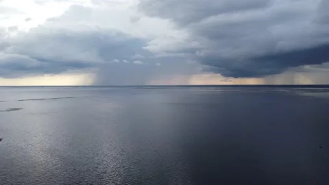 Drone flying backwards over a huge lake revealing the shore line and road Stock Footage 154825607
