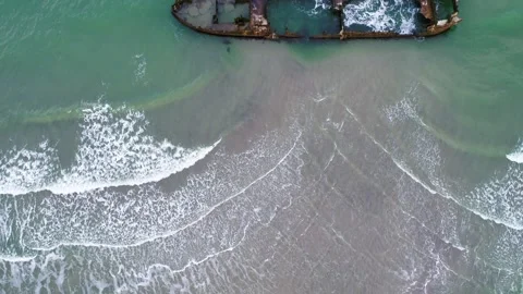 Drone flying backwards over old rusty shipwreck at the coast in Denmark Video stock 283072176
