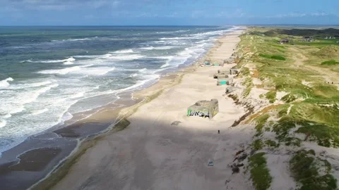 Drone flying backwards over old World War 2 bunkers at the Danish West coast Stock Footage 335993154