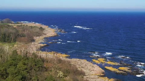 Drone flying backwards over the rocky shores of the Danish island Bornholm Video stock 314213329